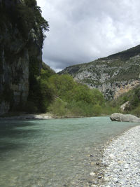 Scenic view of river and mountains against sky