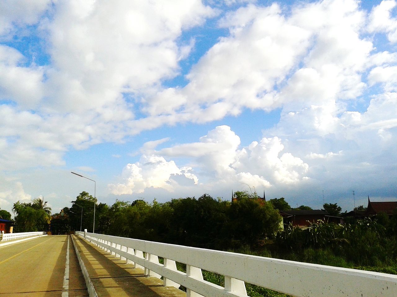 the way forward, sky, transportation, tree, cloud - sky, vanishing point, diminishing perspective, road, railroad track, cloud, built structure, road marking, cloudy, railing, architecture, building exterior, day, rail transportation, outdoors, growth