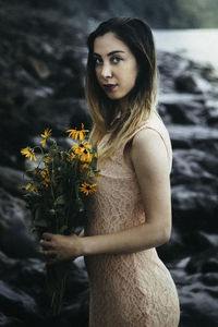 Side view portrait of woman holding flowers