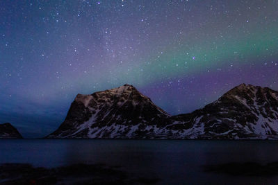 Scenic view of snowcapped mountains against sky at night