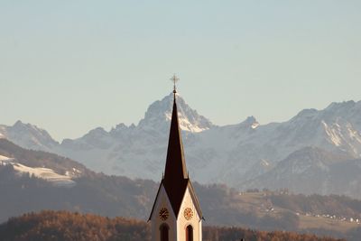 Low angle view of building and mountains against clear sky