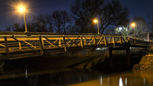 Illuminated bridge against sky at night