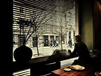 Silhouette of woman sitting on window