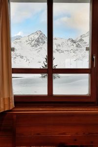 Scenic view of snowcapped mountains seen through window