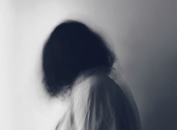 Portrait of woman standing against wall