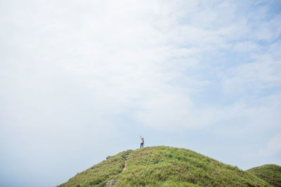 Man standing on hill against sky