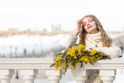 A woman  with a bouquet of yellow acacia flowers.the concept of the- march 8, easter, women's day.