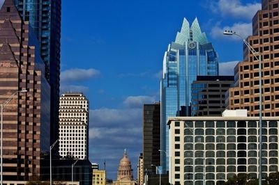 Low angle view of modern buildings against cloudy sky