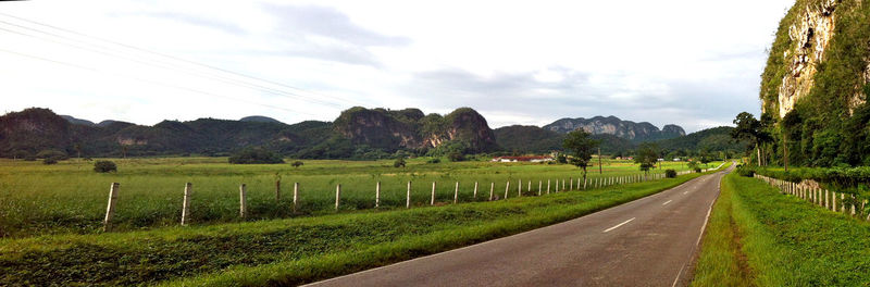 Road amidst field against sky