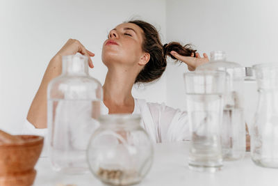 Girl sitting at a table with glass vessels