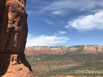 Rock formations on landscape against cloudy sky