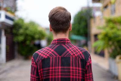 Rear view of man standing against city