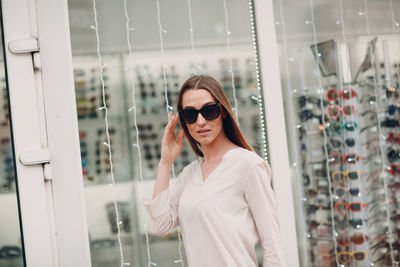 Young woman wearing sunglasses while standing in store