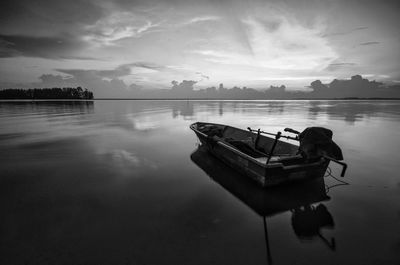 Boat moored in lake against sky