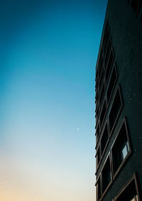 Low angle view of modern building against blue sky