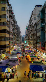 People on street amidst buildings in city