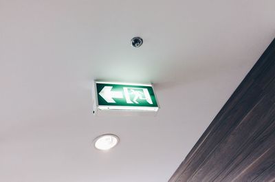 Low angle view of illuminated lighting equipment on ceiling