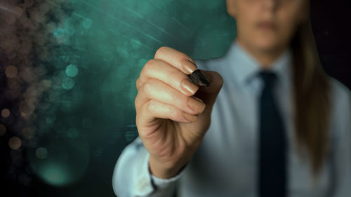 Midsection of man holding mobile phone