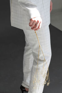 Midsection of businesswoman holding twig while standing indoors