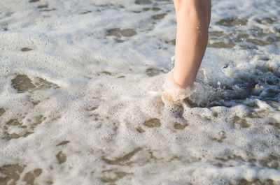Low section of child on sandy beach