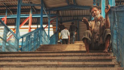 Low angle view of people sitting on staircase