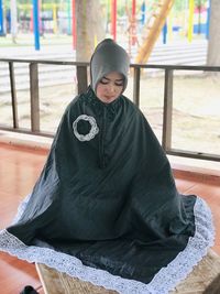 Woman wearing hijab praying indoors