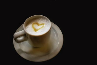 Close-up of coffee cup over black background