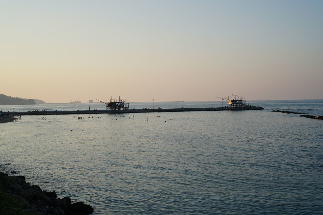 PIER OVER SEA AGAINST SKY DURING SUNSET