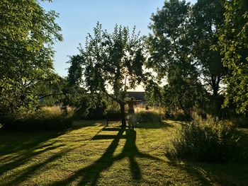 Shadow of person on golf course against sky