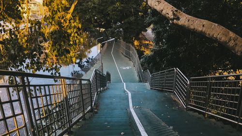 Footbridge over road amidst trees during autumn