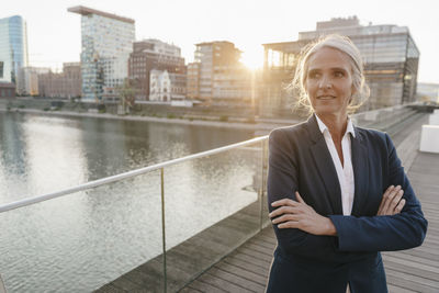 Confident businesswoman standing on bridge