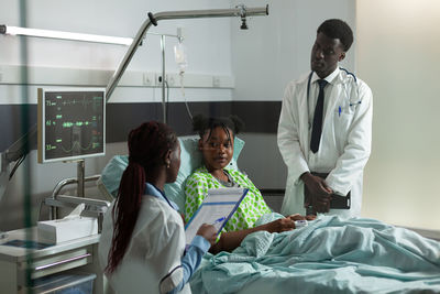 Doctors talking with patient in hospital