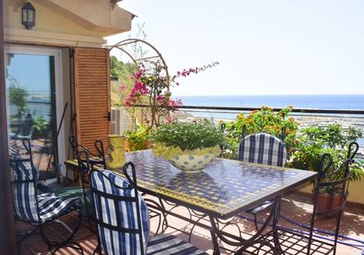 Chairs and table in balcony against sea