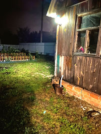 Lawn outside house on field against sky at night