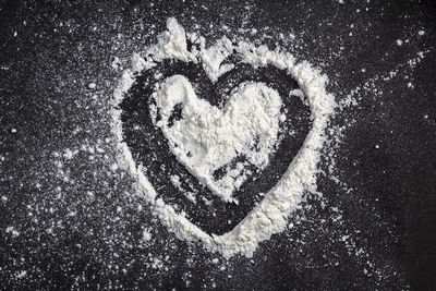 Heart shaped powder on a black background
