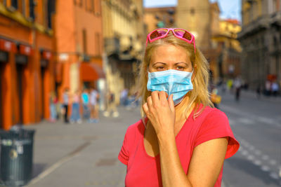 Portrait of woman standing on street in city