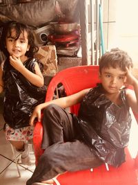 Siblings sitting on chairs 