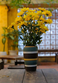 Close-up of yellow flower pot on table