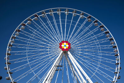 Low angle view of ferris wheel against blue sky