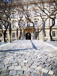 Cobblestone street amidst buildings in city