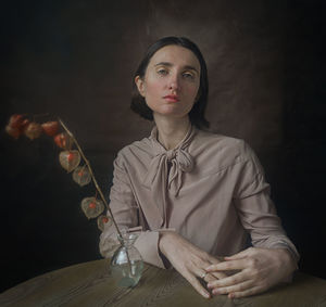 Portrait of young woman sitting at table
