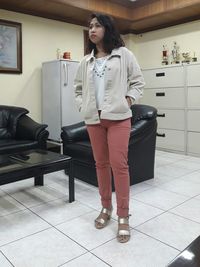 Full length of young woman standing in kitchen