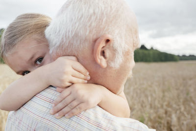 Granddaughter hugging her grandfather outdoors