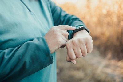 Midsection of woman checking time outdoors