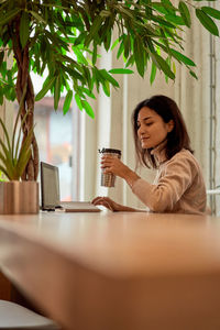 Businesswoman drinking coffee at cafe