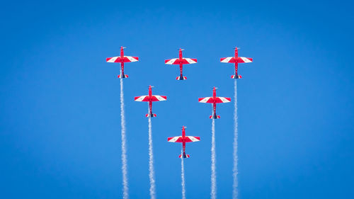 Low angle view of airplane flying against blue sky