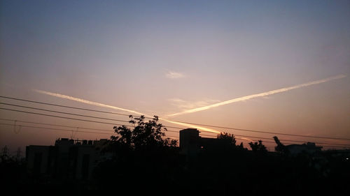 Low angle view of silhouette cables against sky during sunset