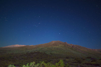 Scenic view of mountains against sky at night