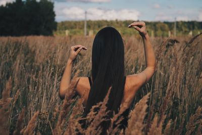 Rear view of woman standing on field