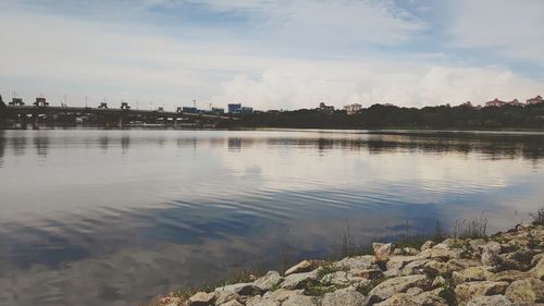 Scenic view of lake against sky in city